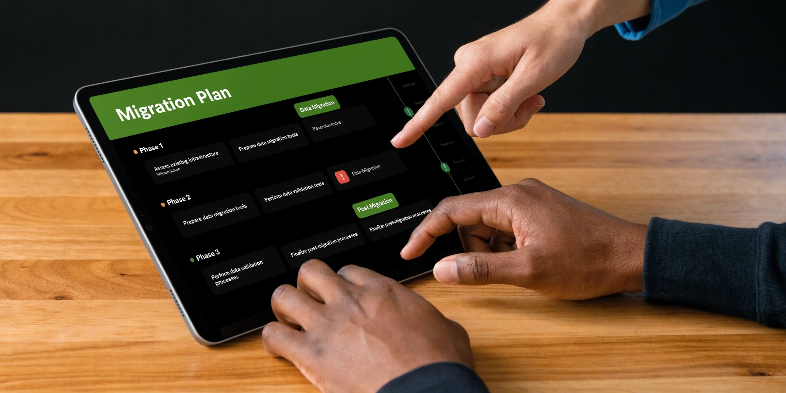 Two people working together on a digital migration plan displayed on a tablet computer.
