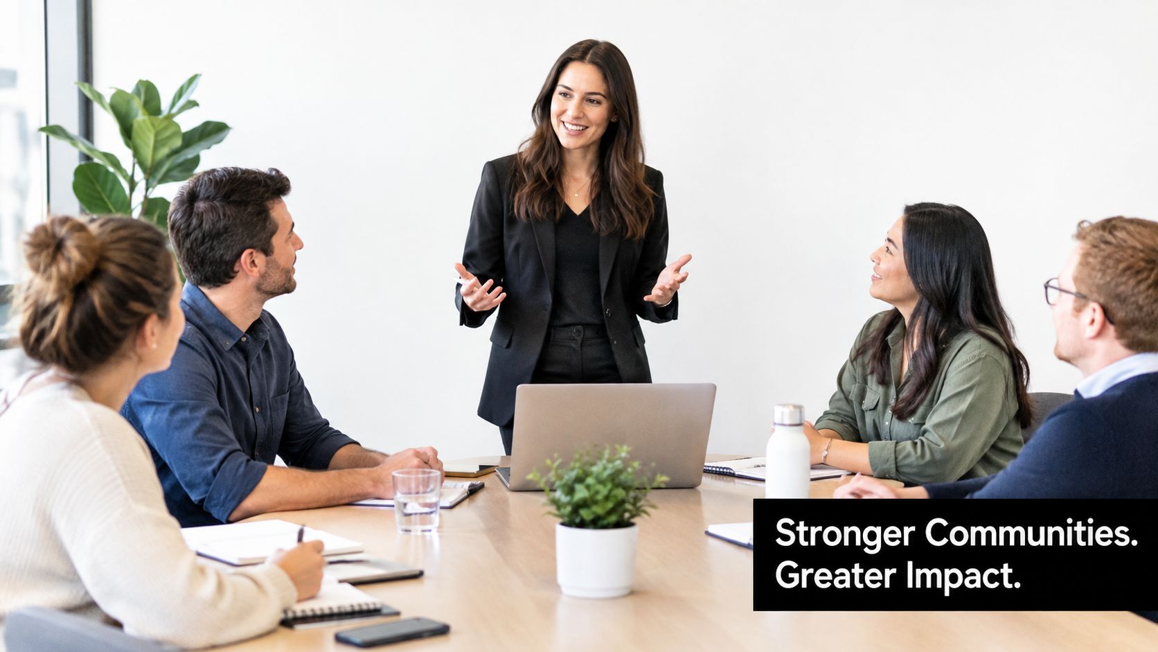 A professional woman presenting to her diverse team during a collaborative business meeting in a bright office.