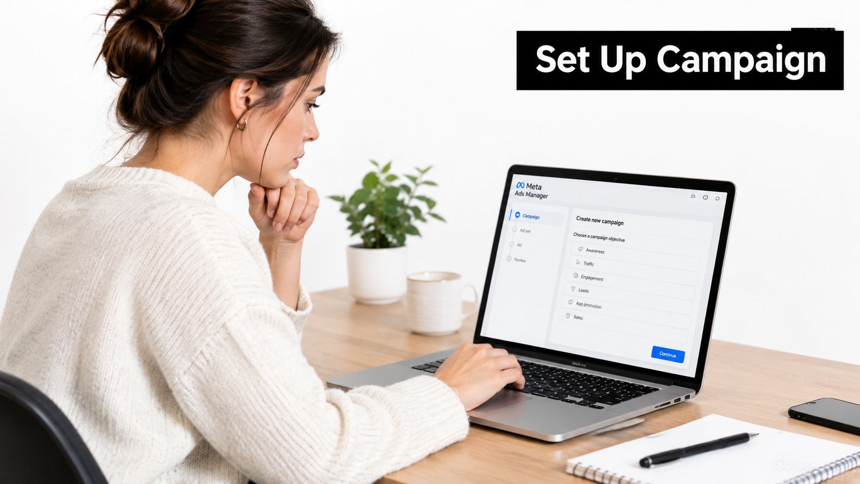 A woman working on a laptop computer to set up a new advertising campaign in Meta Ads Manager.